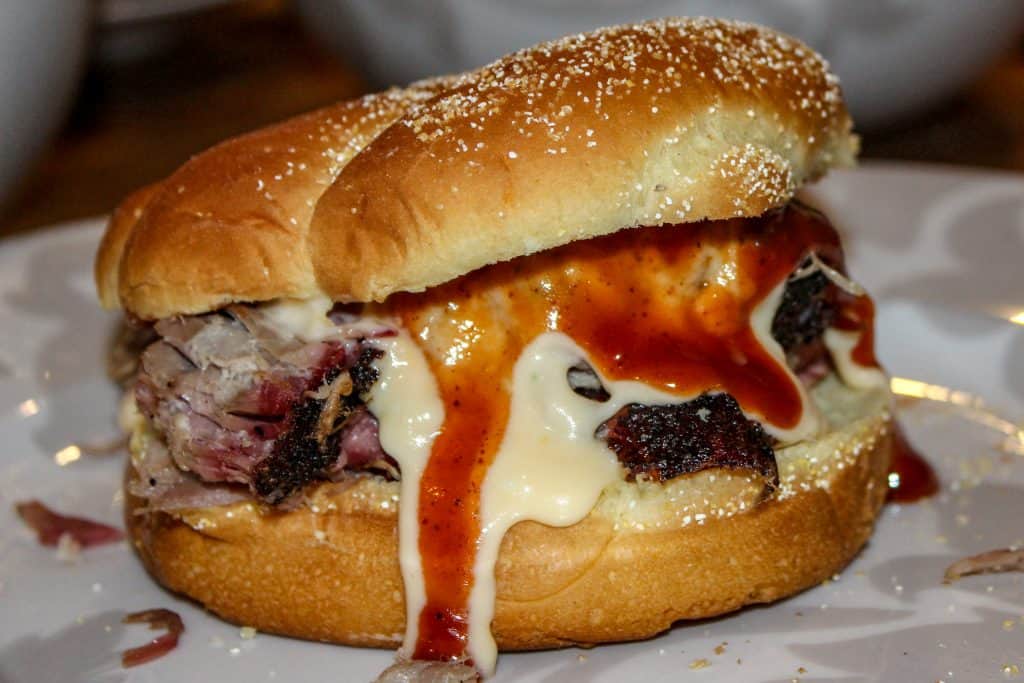 picture of a pulled pork sandwich with smoked cheese sauce