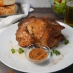 Whole chicken with seasonings on platter