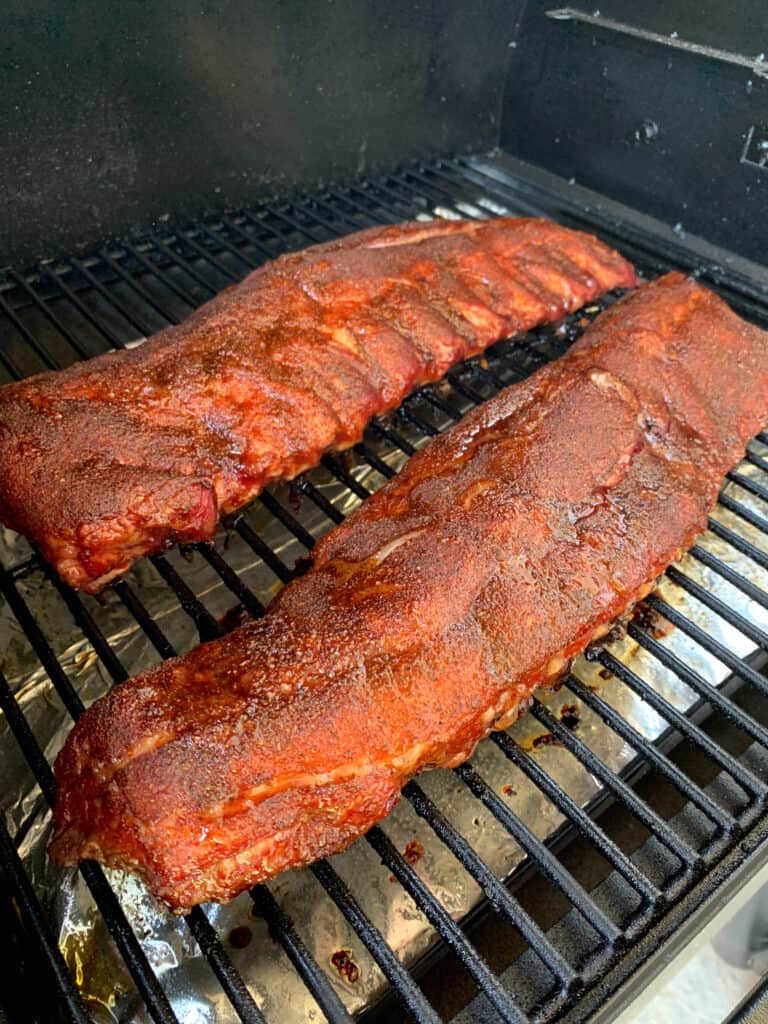 ribs on the grill grate of a smoker