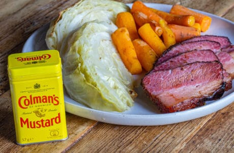 A Plate of Smoked Corned Beef Brisket, carrots, and cabbage with a container of Colman's Dry Mustard
