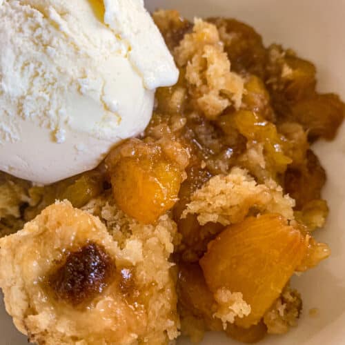 Smoked Peach Cobbler with a Scoop of Vanilla Ice Cream in a bowl