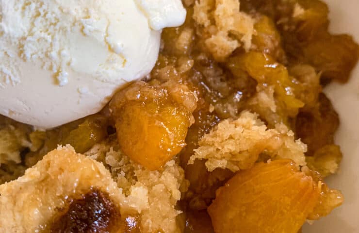 Smoked Peach Cobbler with a Scoop of Vanilla Ice Cream in a bowl