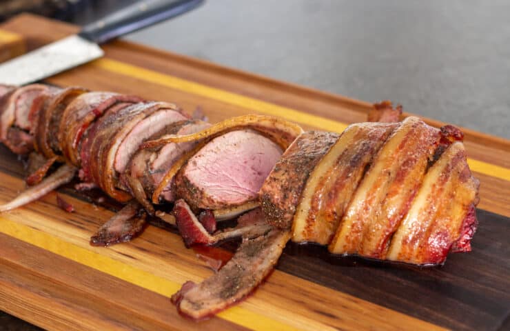 partially sliced bacon wrapped pork tenderloin