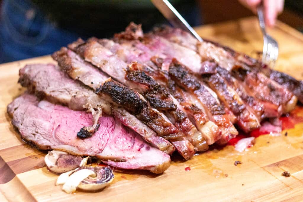 smoked prime rib, sliced on a cutting board