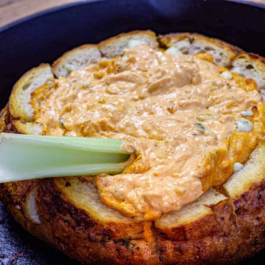 smoked buffalo chicken dip recipe in a bread bowl with celery