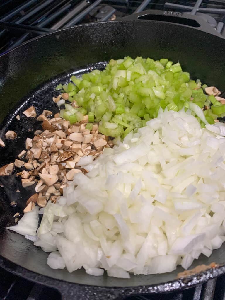 chopped celery, onion, and mushrooms in a cast iron skillet