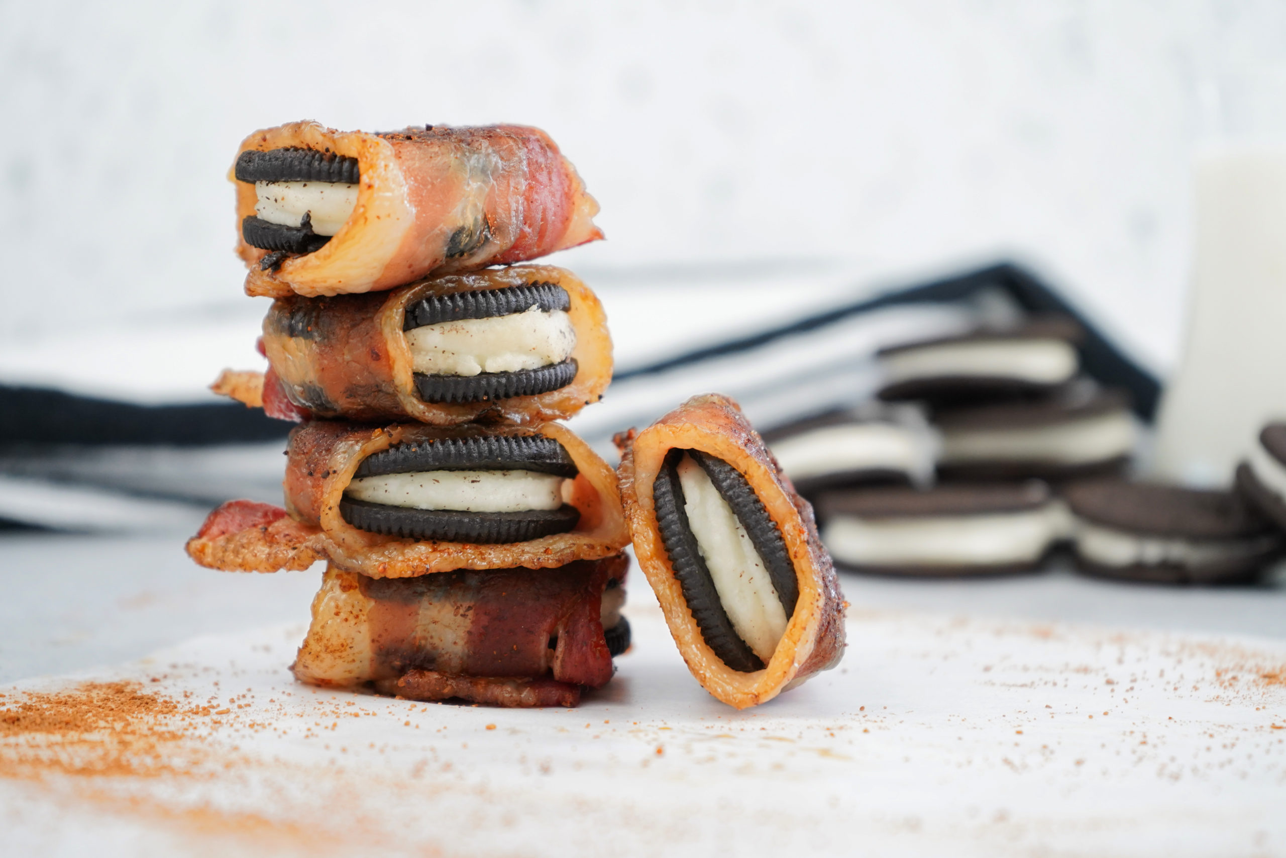 Smoked oreoes with bacon stacked with cookies in background. 