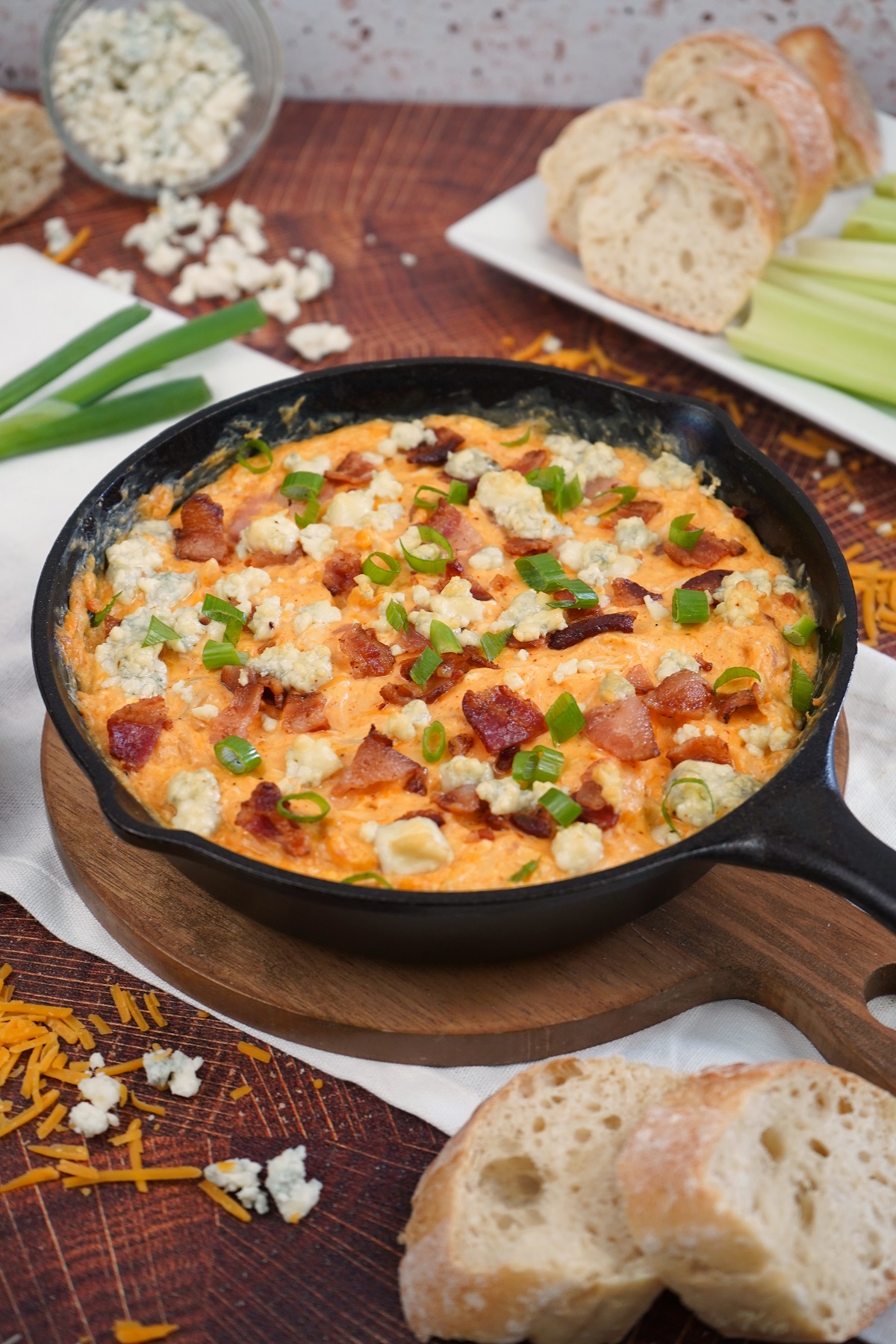 The Best smoked buffalo chicken dip in skillet with toppings. 
