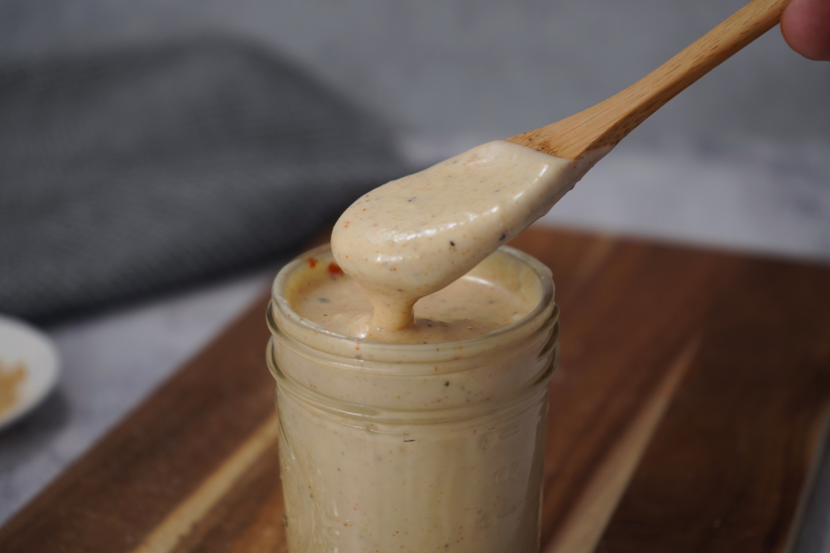 Alabama white sauce on wooden spoon.